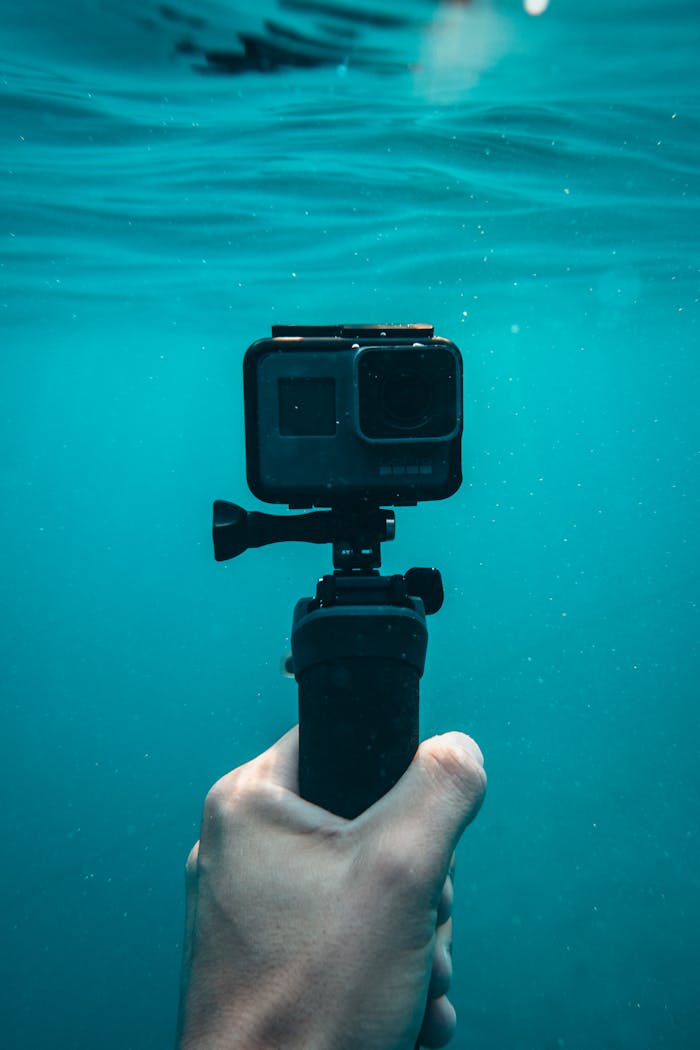 A hand holding an action camera underwater in Jezerane, Croatia.